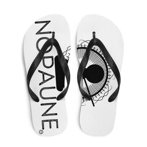 A pair of white flip-flops with black toe straps. The word "Nopaune"  is printed on the left flip-flop, and the Nopaune symbol(a chess pawn with a "not allowed sign" laid over it, surrounded by spokes/rays and broken infinity signs) can be seen on the right flip-flop.